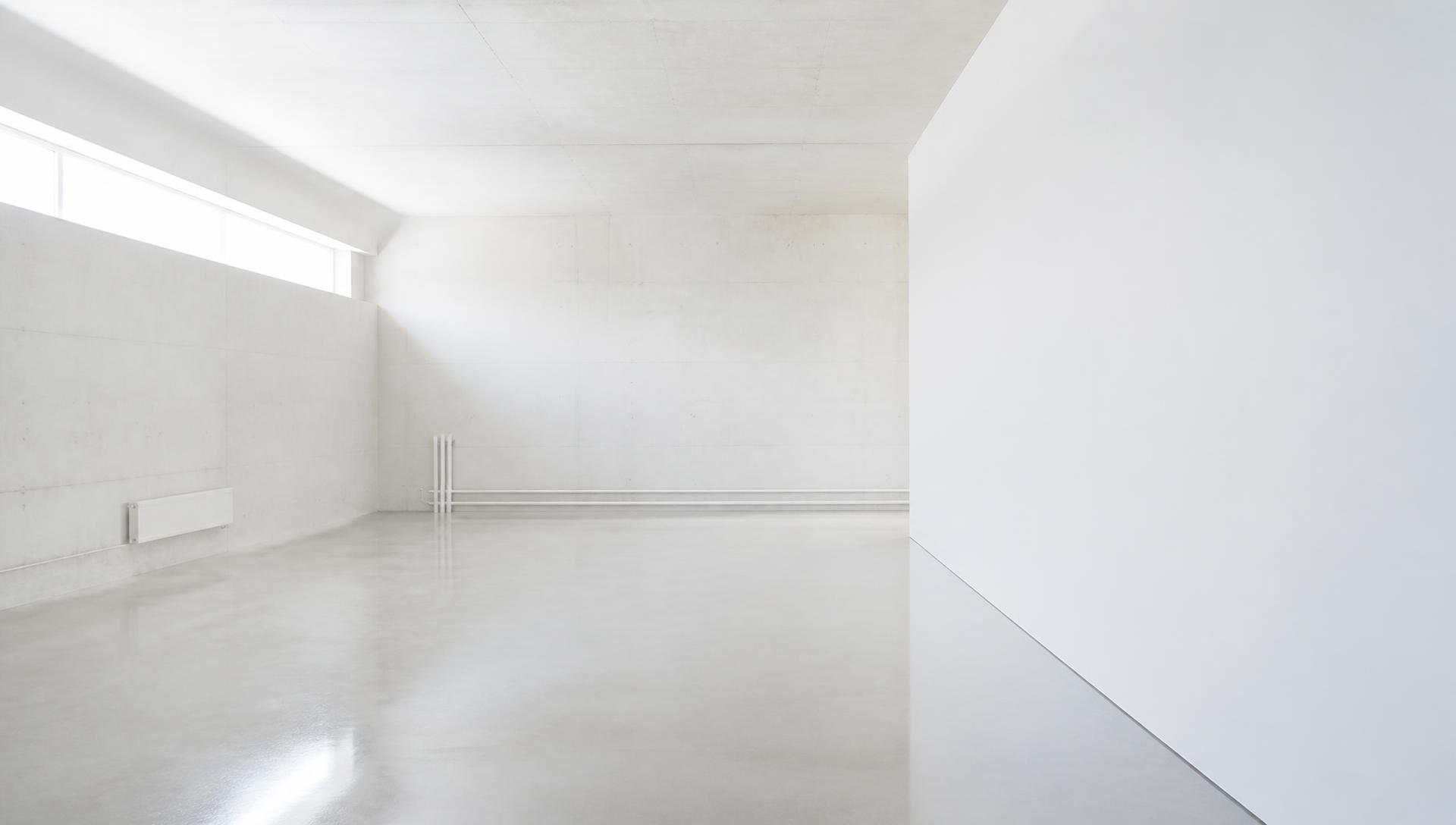 An empty pale concrete technical room, the kind of space a first Node could occupy
